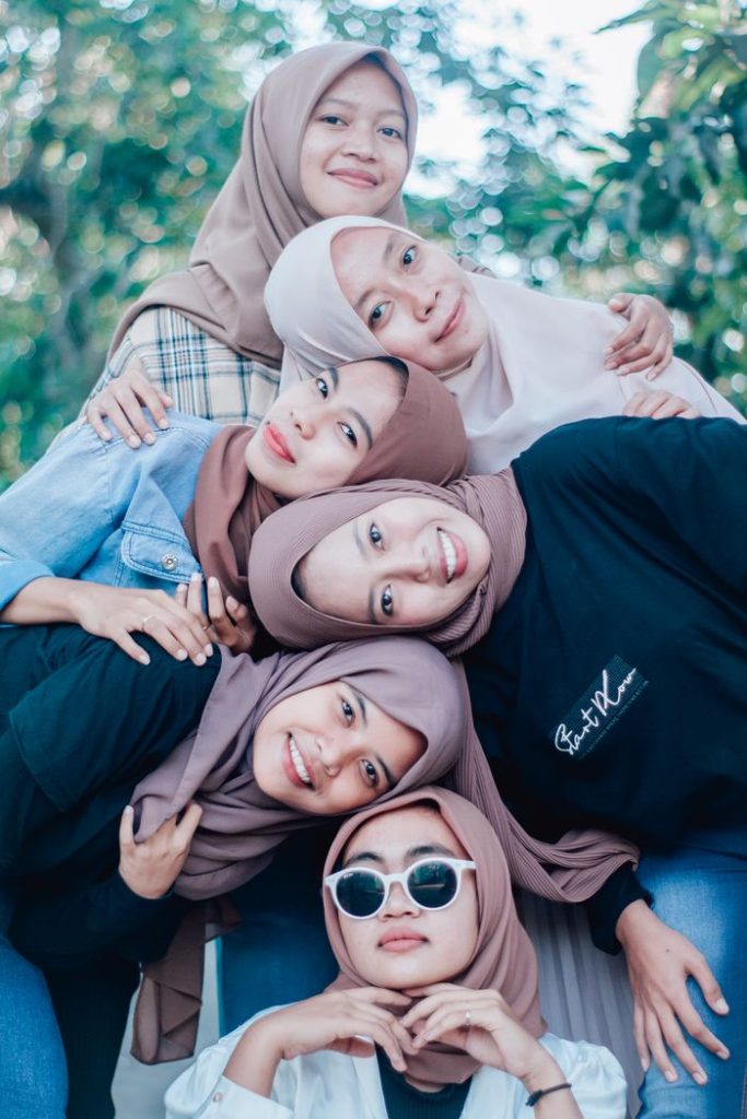 pexels photo 9923253 Lovely portrait of cheerful young women in hijabs enjoying a day outdoors together.